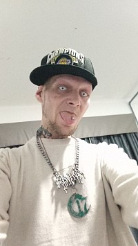 0N3R1 Tha Wicced 1 in a Hotel on New Year's 2026 sticking his tongue and tongue piercing out wearing whiteout contact lenses and a Chapter17 Records Necklace
